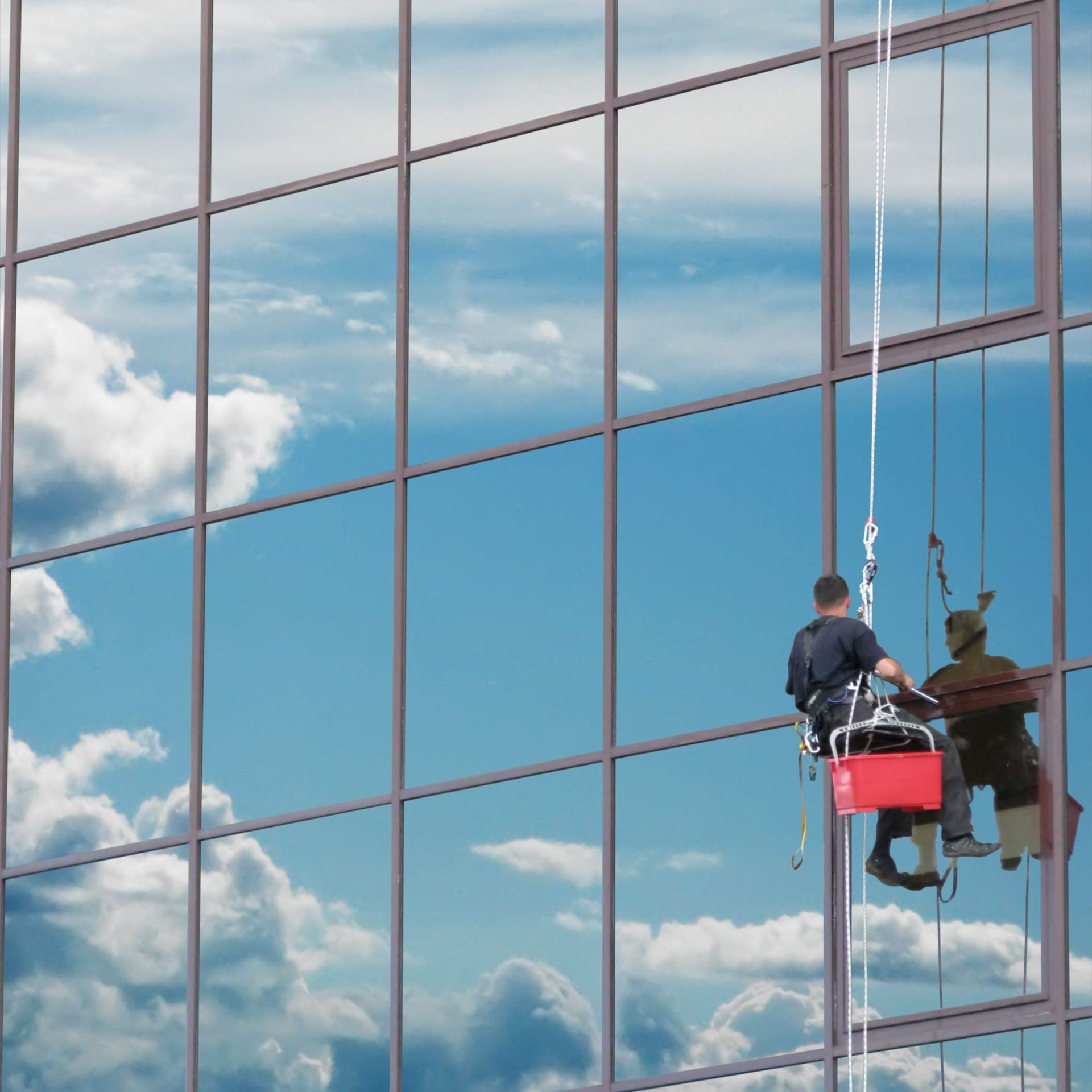 4328397 - window washer at work and reflect the sky in the windows